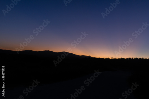 dark landscape with the last rays of the sun photo