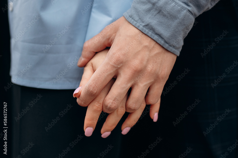 The touch of the hands of a man and a woman. Strong gentle hugs by the hands of two lovers. Young couple's hands close up. The feeling of love The touch of the hands of a man and a woman. Strong gentle hugs by the hands of two lovers. Young couple's hands close up. The feeling of love
