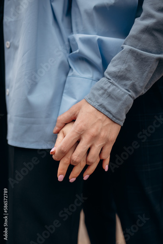 The touch of the hands of a man and a woman. Strong gentle hugs by the hands of two lovers. Young couple's hands close up. The feeling of love