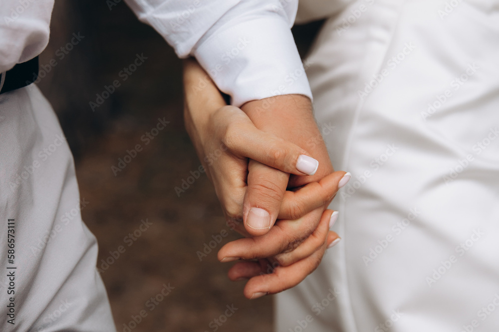 The touch of the hands of a man and a woman. Strong gentle hugs by the hands of two lovers. Young couple's hands close up. The feeling of love