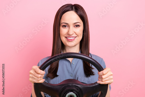 Closeup photo of car driver young girl test simulator hold steering wheel new volkswagen group automobile safety isolated on pink color background
