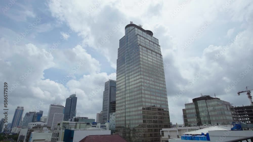 View of Office and Commercial Buildings in Jakarta Indonesia against a clear blue sky with moving clouds. View of Office and Commercial Buildings in Jakarta Indonesia against a clear blue sky with moving clouds.