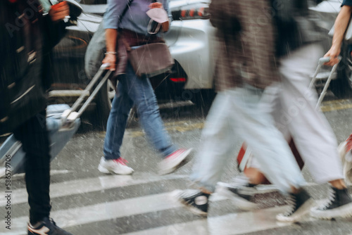 Fototapeta Naklejka Na Ścianę i Meble -  Paris, France - 26.09.2021 : People crossing the street in Paris in the rain, the image is specially blurred