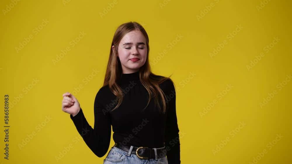 4k video of one girl pointing at right over yellow background. 4k video of one girl pointing at right over yellow background.