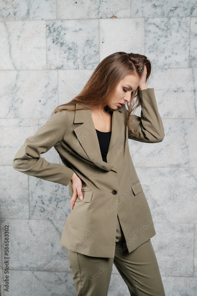 beautiful lady posing in a green business suit. Employee and business concept.