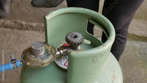 LPG cylinder connection with pressure regulator. close-up of a technician connecting a gas cylinder. pvc pipe. bottle sealed and ready to use.