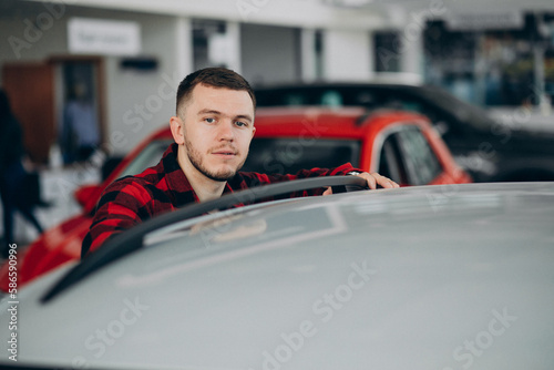 Handsome man choosing car in a car showroom