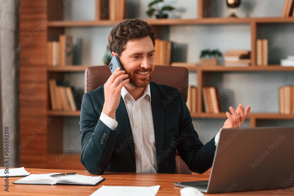 Having phone call. Businessman in formal clothes is working indoors Having phone call. Businessman in formal clothes is working indoors