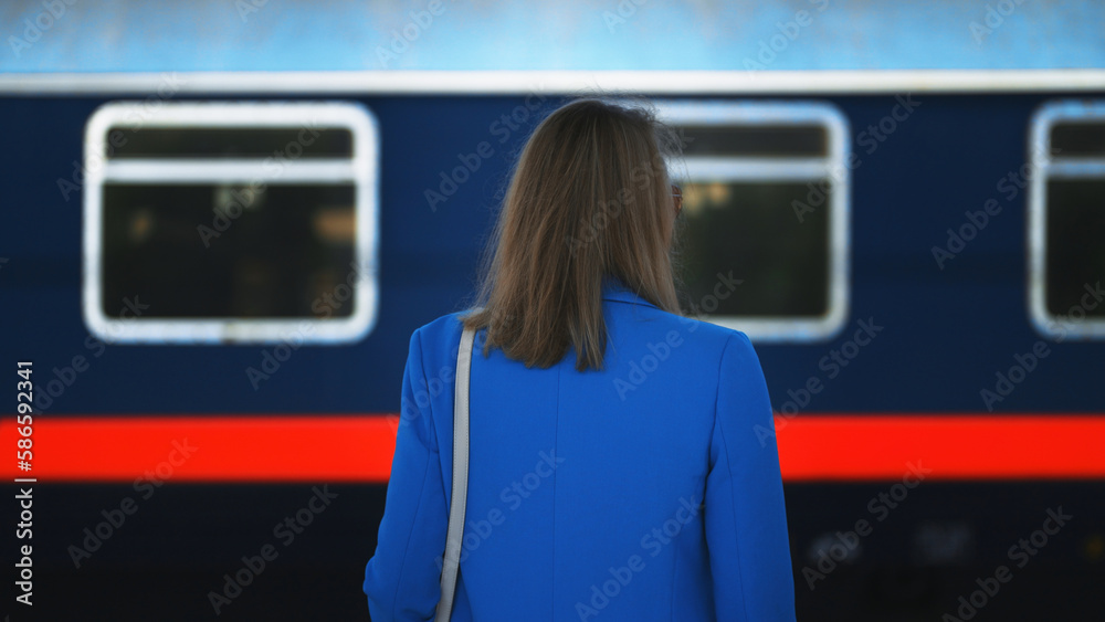 Woman looks at a train passing by.