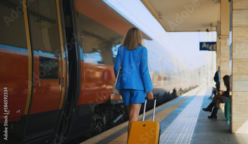 Woman walks along the platform at the train station.