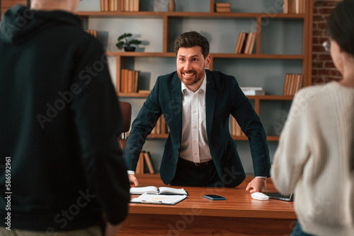 The boss shouts at subordinates. Businessman in formal clothes is working indoors