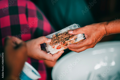Volunteers serving hot meals to hungry migrants: humanitarian aid concept.