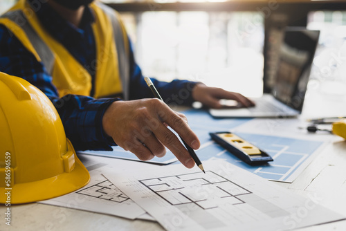 Architect design working drawing sketch plans blueprints and making architectural construction model in architect studio. Engineer is working on residential construction project design on blueprints.