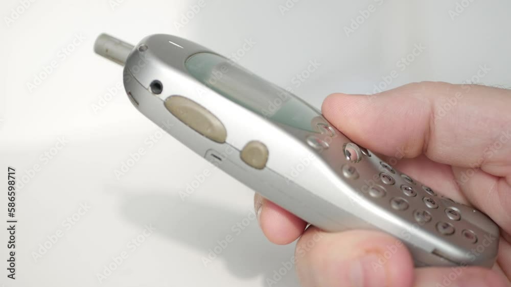 Closeup Blurred Shooting with One Person Dialing a Phone Number Using an Old Technology Mobile Phone. Texting Using an Old Phone. Closeup Blurred Shooting with One Person Dialing a Phone Number Using an Old Technology Mobile Phone. Texting Using an Old Phone.