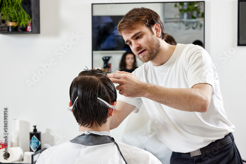 Professional barber during work with man client
