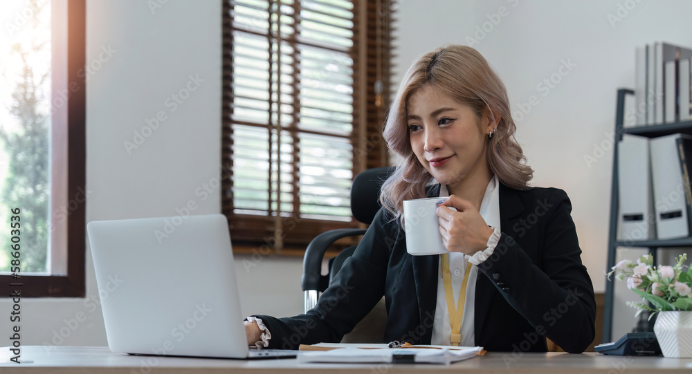 Asian woman business using a calculator calculating financial expense at home office Asian woman business using a calculator calculating financial expense at home office