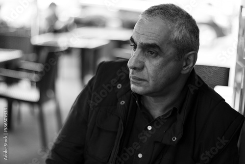 Sad older man thinking about something while sitting at the bar. Thoughtful senior man sitting at table