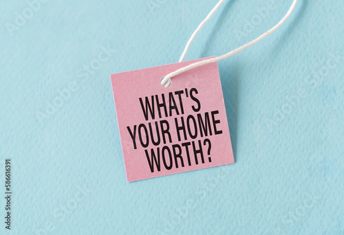 What's Your Home Worth text quote on a pink card, Business Concept on Blue Background.