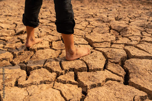 Drought. girl's legs on dry ground. Water crisis, Concept drought and crisis environment.