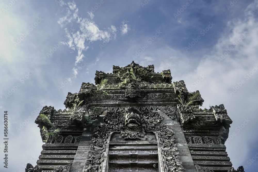 Balinese traditional gate during the day with blue sky background. Balinese traditional gate during the day with blue sky background.