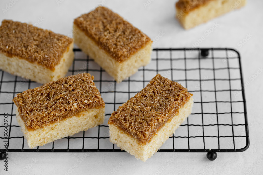 Danish Dream Cake Drømmekage. Sponge cake with coconut and brown sugar topping on a light background. 