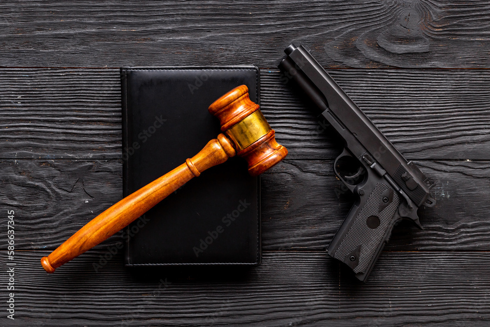 Gun law concept. Hand gun weapon and judges gavel. Crime background