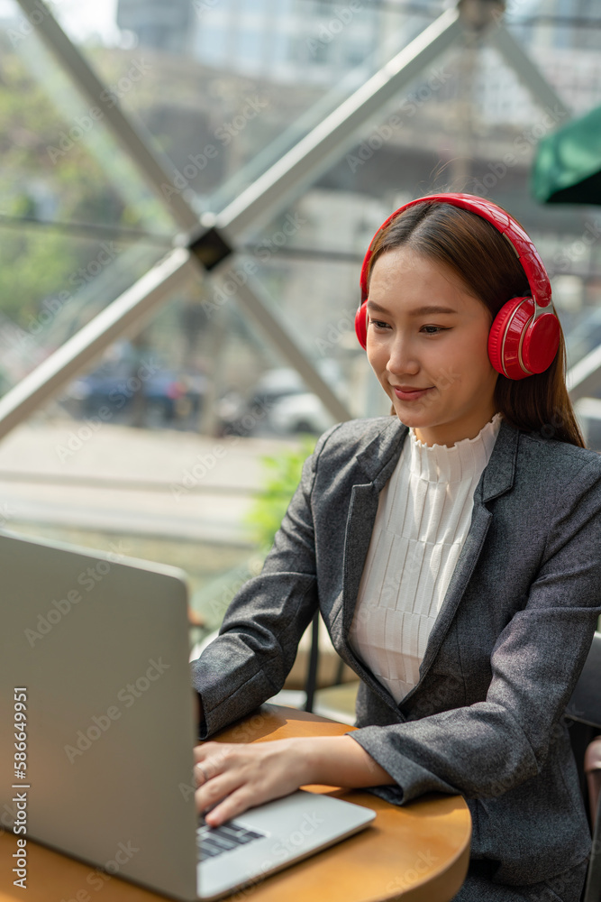 Young asian businesswoman working on her computer laptop and wearing a ...