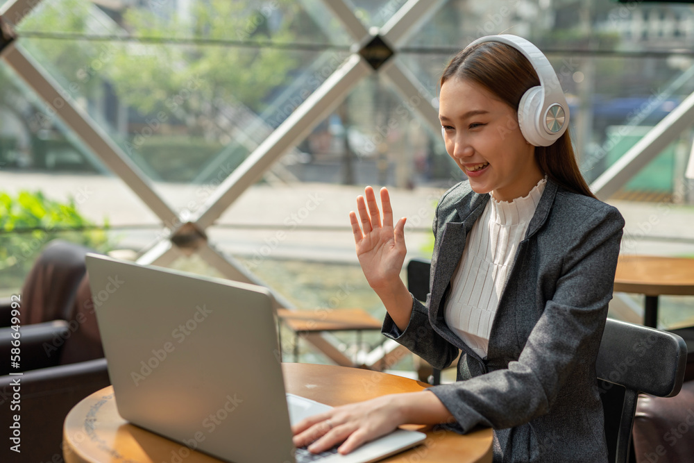 Young asian businesswoman working on her computer laptop and wearing a ...