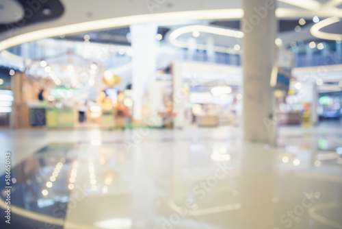 Defocus of shopping mall. Include empty space on white tile floor, modern interior decoration design for background, product display and concept of shopping center, retail, business and lifestyle.