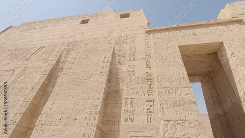 Hieroglyphic carvings and statues with columns at the ancient Egyptian Medinat Habu Temple in Luxor Egypt photo