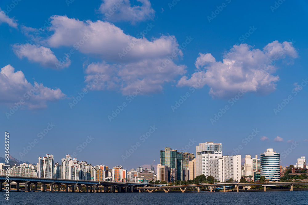 Fototapeta premium Seoul cityscapes, skyline, high rise office buildings and skyscrapers in Seoul city, winter daylight, top view in winter, Seoul, Republic of Korea, in mist winter season with blue sky and cloud