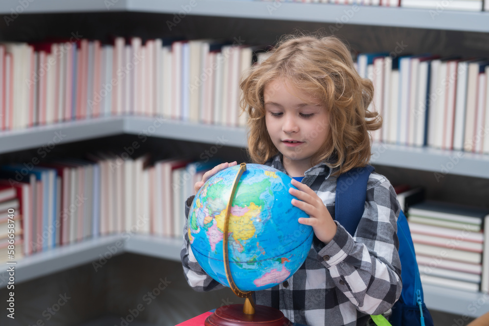Explorer and discovery. School kid pupil looking at globe in library at the elementary school. World globe. School kid 7-8 years old with book go back to school. Little student. Education concept. Explorer and discovery. School kid pupil looking at globe in library at the elementary school. World globe. School kid 7-8 years old with book go back to school. Little student. Education concept.