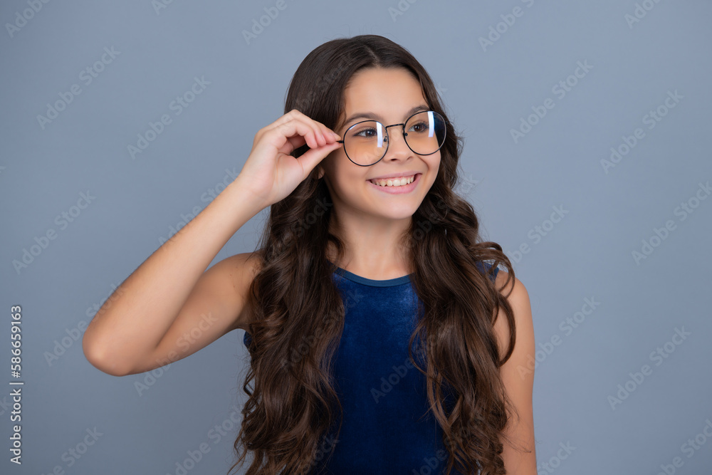 Happy girl face, positive and smiling emotions. Teenager child wearing glasses on gray studio background. Cute girl in eyeglasses. Happy girl face, positive and smiling emotions. Teenager child wearing glasses on gray studio background. Cute girl in eyeglasses.