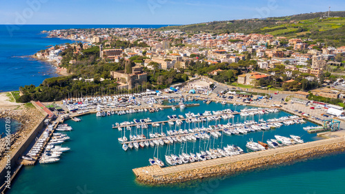 Aerial view of the marina and port of Santa Marinella, in the Metropolitan City of Rome, Italy. In the background the town overlooking the Tyrrhenian Sea. There are many boats moored at the harbour. photo