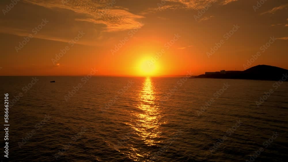 Beautiful cloudscape over the sea, sunset shot. Sun reflecting on sparkling sea, ocean at sunset, Asia, Vietnam. Drone aerial view dolly side panning over paradise beach sunrise. 4K.