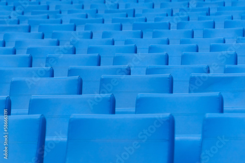 Seats at the stadium. Empty seats in the stands of the arena or auditorium. Rows of blue seats without spectators.