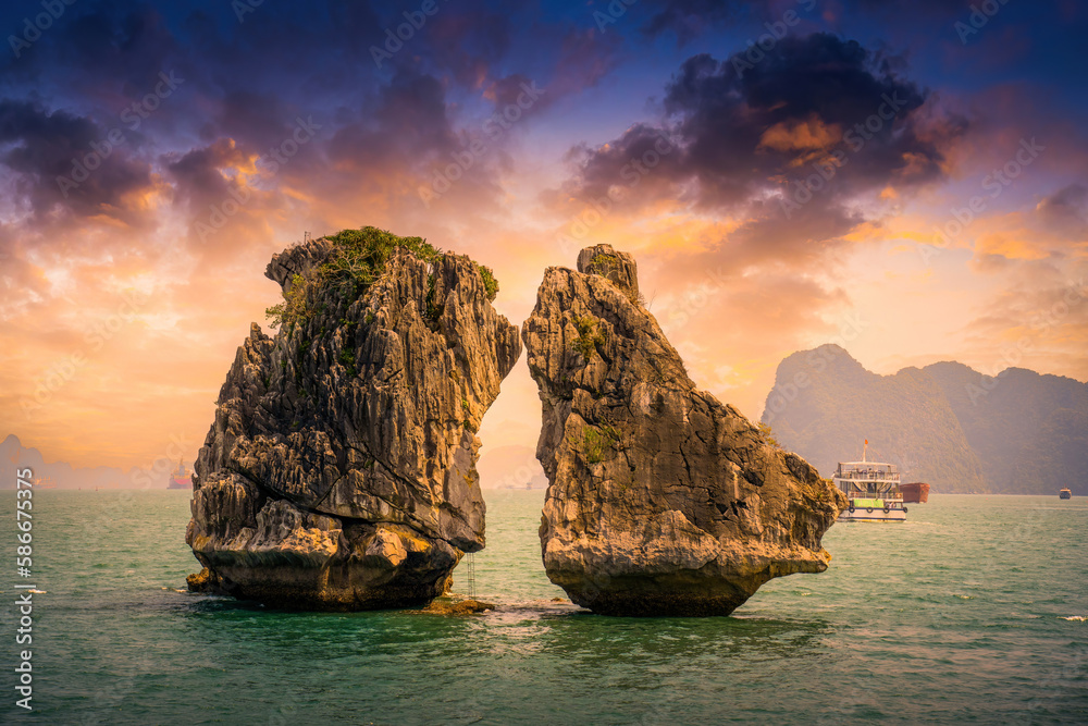 View of Hon Ga Choi Island or Cock and Hen, Fighting Cocks Island located in Ha Long bay, Vietnam, Trong Mai island, junk boat cruise and boats, popular landmark