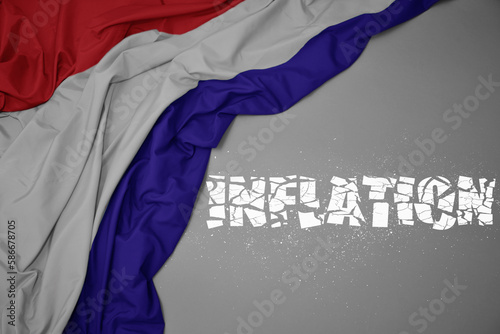 waving colorful national flag of netherlands on a gray background with broken text inflation. 3d illustration