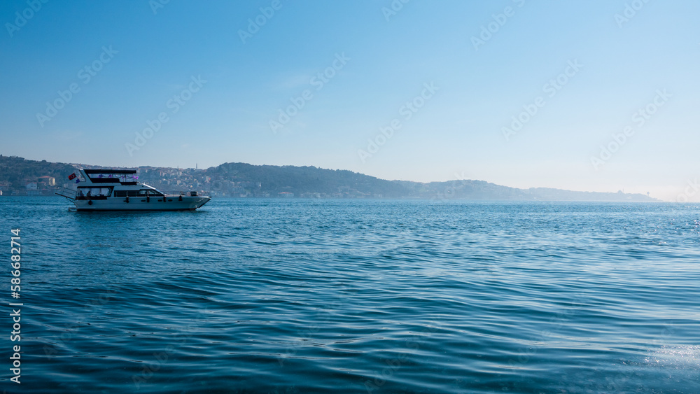 A tour boat sailing off the shores of Ortakoy in the Bosphorus, Istanbul.