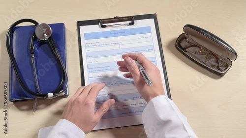Doctor's hand takes pen, tries to fill in medical card, takes glasses from spectacle case, takes magnifying glass to read, stethoscope on table, short sighted, medicine. Close up, 4K Ultra HD.