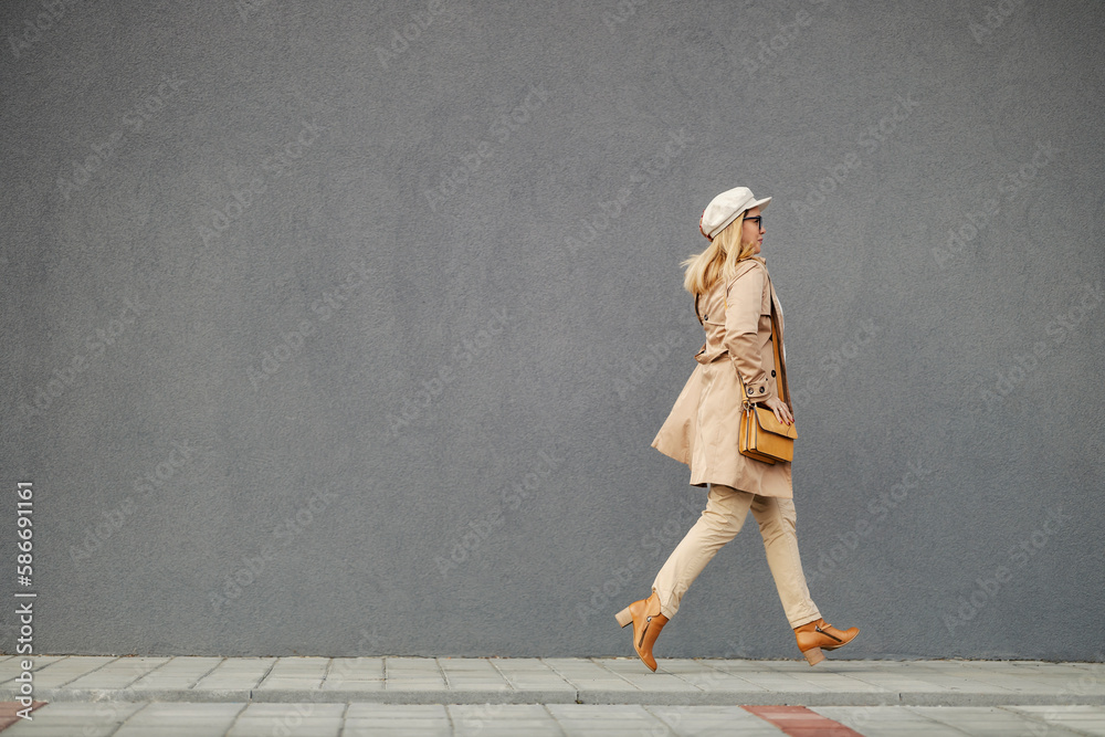 A busy woman in smart casual is running on the street and rushing to work.