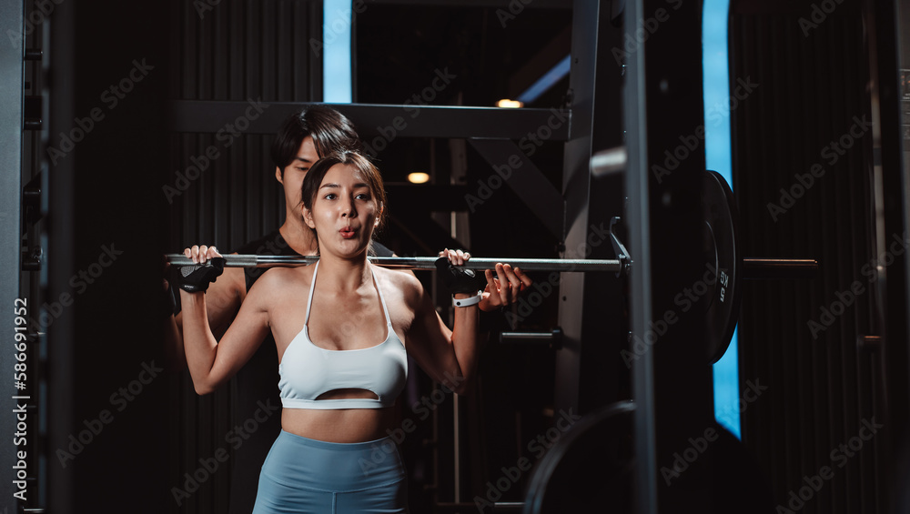 Woman working out Bodybuilder with coaching assistance to support weights at the gym. bodybuilder doing exercises with barbell. training sport healthy lifestyle bodybuilding...