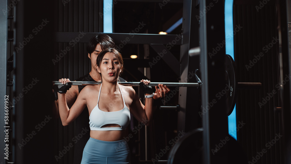 Woman working out Bodybuilder with coaching assistance to support weights at the gym. bodybuilder doing exercises with barbell. training sport healthy lifestyle bodybuilding... Woman working out Bodybuilder with coaching assistance to support weights at the gym. bodybuilder doing exercises with barbell. training sport healthy lifestyle bodybuilding...