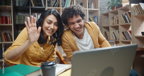 Asian students having a video conference with their international friends or distant relatives, expressively gesturing and talking close up  photo