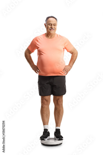 Mature man in sportswear standing on a weight scale and looking down