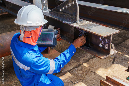 Inspectors are checking defects in welded steel h-beam add joint with process Ultrasonic testing (UT) of Non-Destructive Testing(NDT)