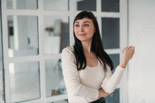 Portrait of a beautiful contented woman in a large white bright room at home. Cheerful brunette woman in white casual clothes Free Download Portrait of a beautiful contented woman in a large white bright room at home. Cheerful brunette woman in white casual clothes - GFXLoad
