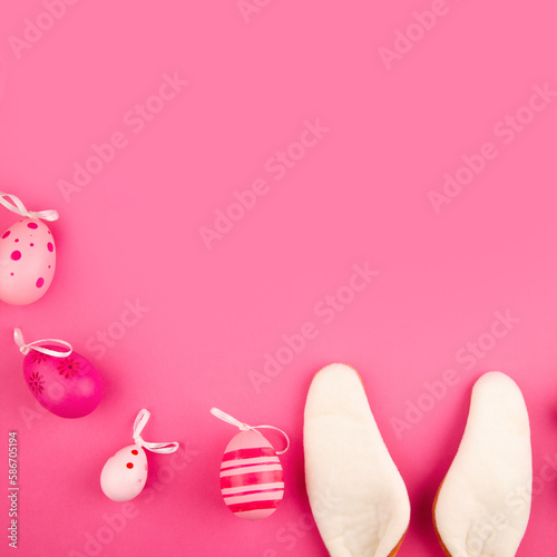 Pink Easter background with copy space, bunny ears and Easter eggs