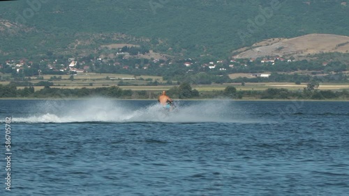 Watercraft, man riding jetski in the sea, speeding and enjoying the adrenaline with the waves splashing photo