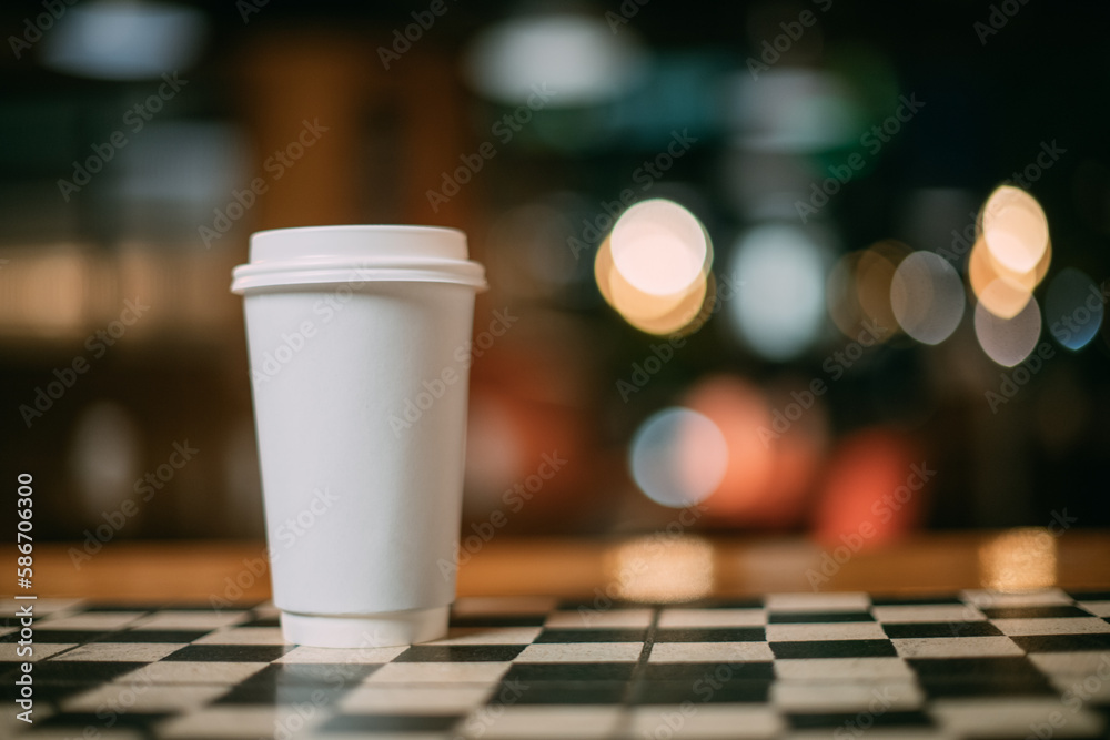 A paper white glass of tea or coffee is a takeaway on the coffee shop table. No one. A paper white glass of tea or coffee is a takeaway on the coffee shop table. No one.